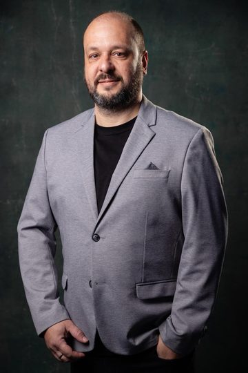 Marcelo Menezes, consultor de SEO, de blazer cinza sobre fundo escuro